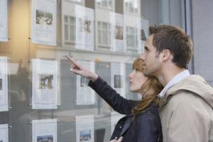 Couple looking at property in the real estate window