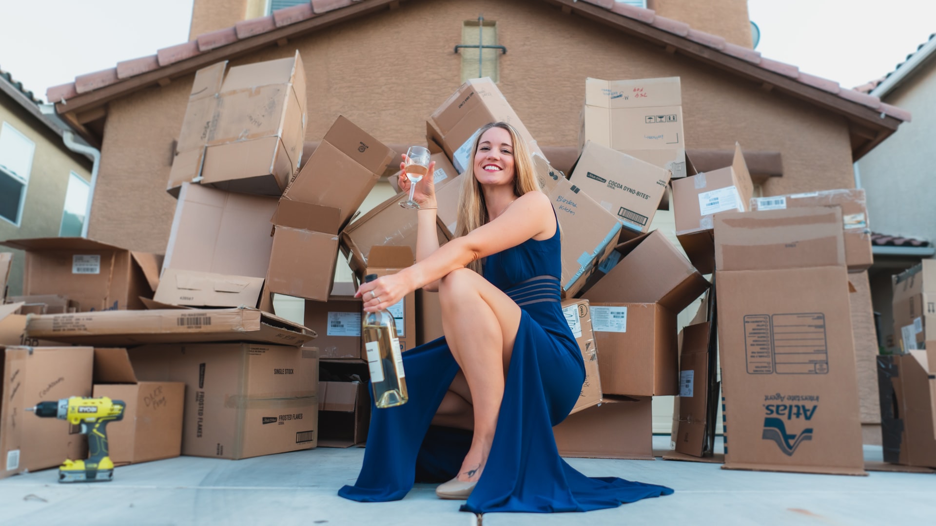 woman moving boxes and drinking wine